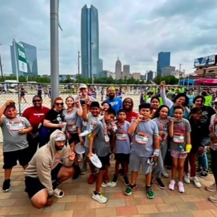 Young runners and community members posing together after a community fun run